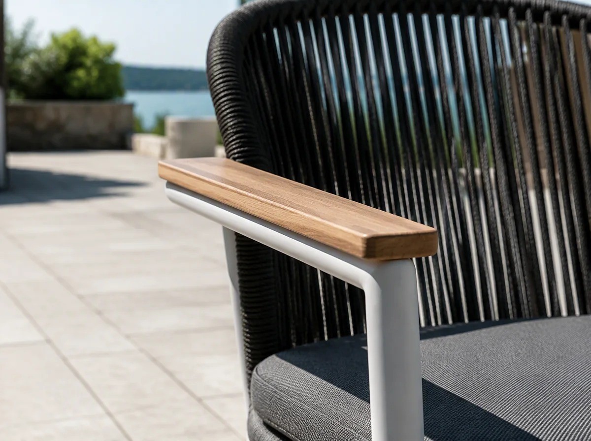 Close view of a short solid light teak board fixed along the top of a matt white round-tube armrest