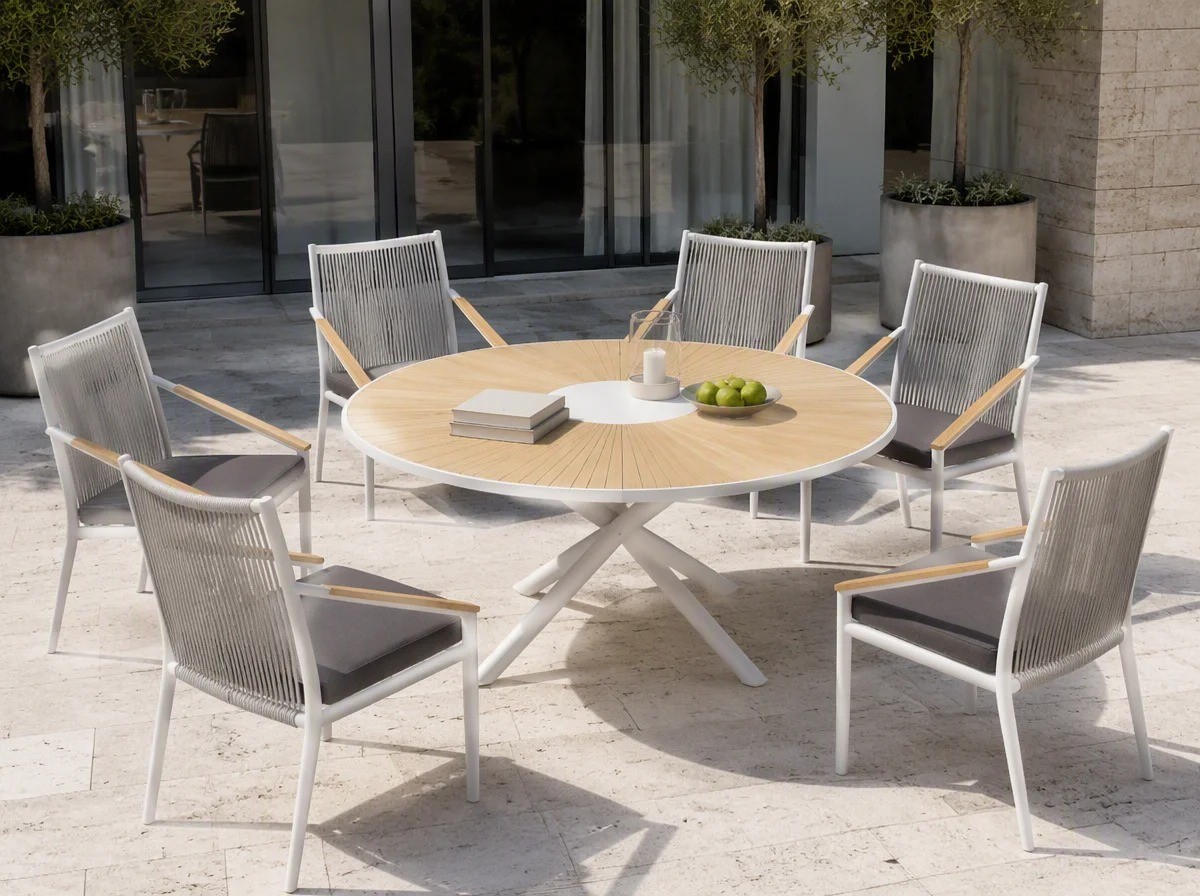 Six rope weave outdoor armchairs with white sloping arms around a round table on a hotel terrace