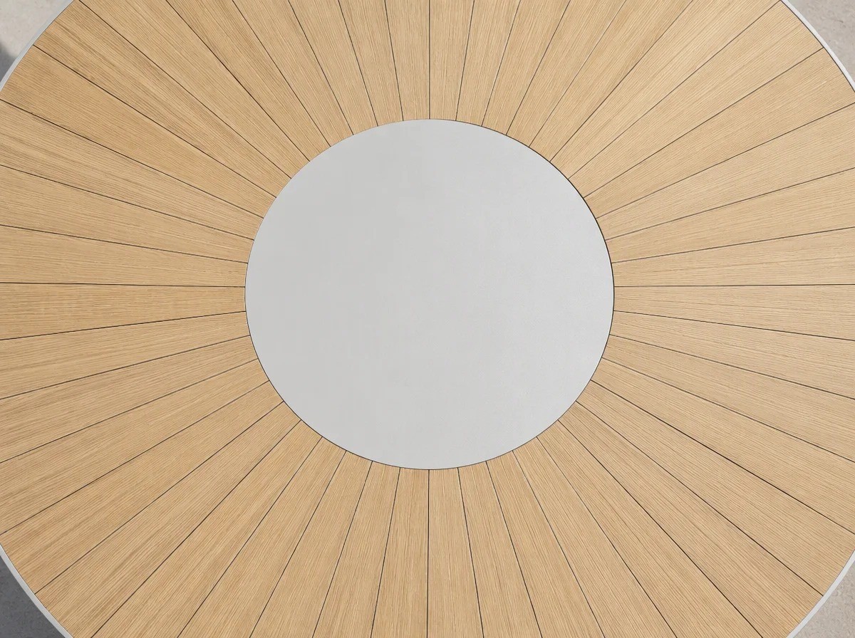 Close view of the central cross base of a round outdoor table: four white legs from under the centre crossing in an X