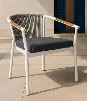 Close view of a thick dark grey loose seat cushion resting on the white frame of a rope-back chair