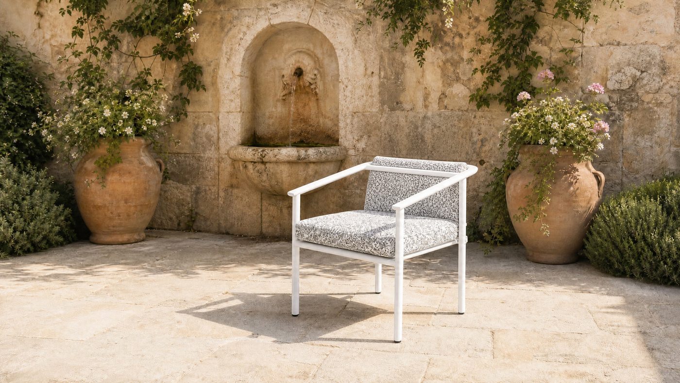 Garden armchair in a stone courtyard with a wall fountain