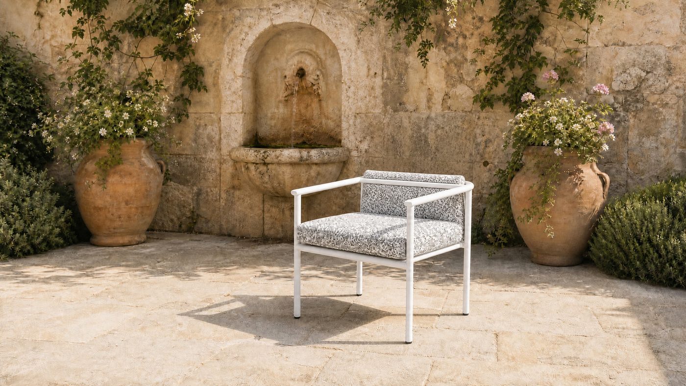 Garden armchair in a stone courtyard with a wall fountain