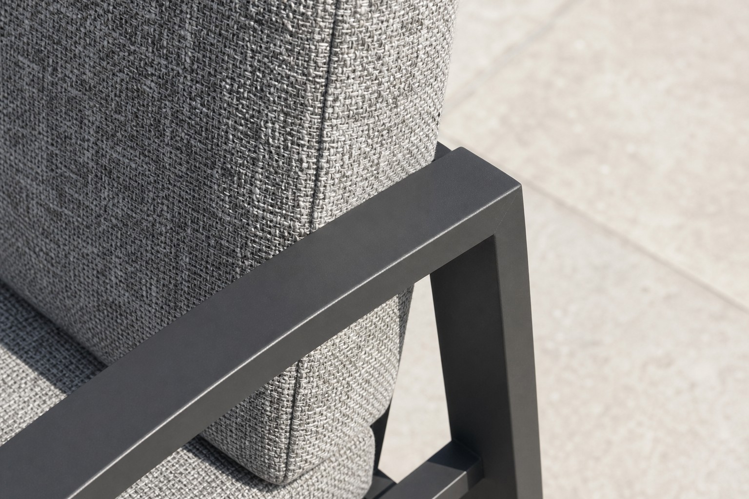 Close view of the joint where the flat dark armrest of the high-back garden chair meets the rear upright