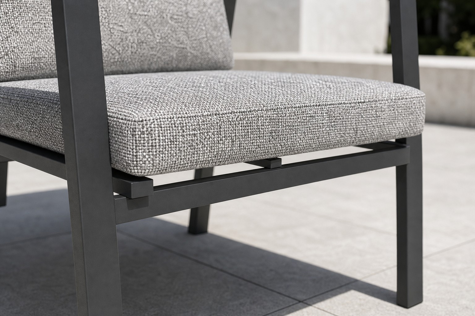Close view of the thick grey seat cushion of the high-back chair sitting on the frame, with the stretcher bars joining the legs underneath