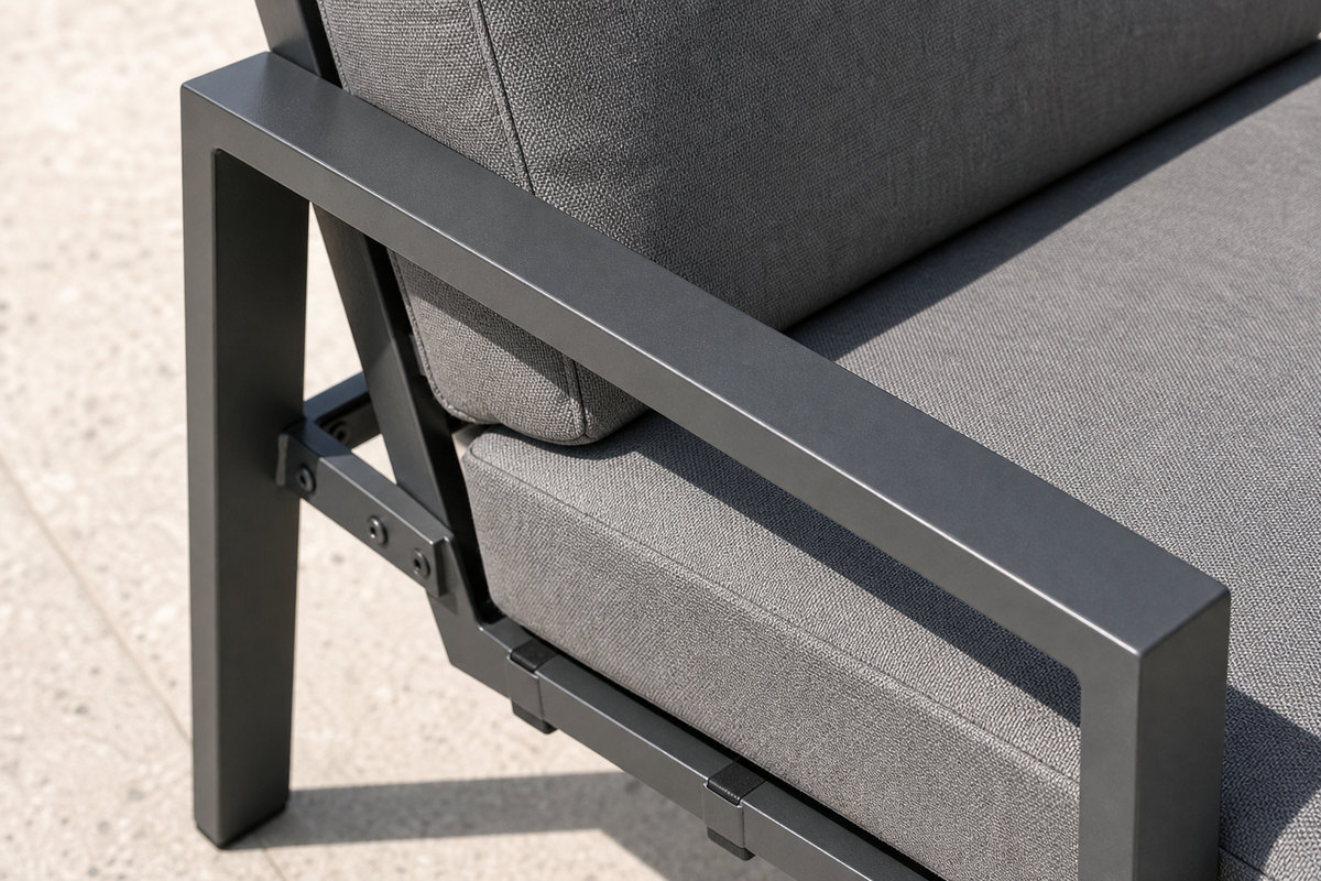 Close view of the square-section charcoal aluminium armrest and bolted frame joint of an outdoor lounge chair