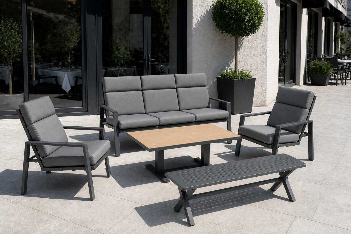 Outdoor sofa set on a restaurant terrace beside a glass frontage with dining tables visible inside