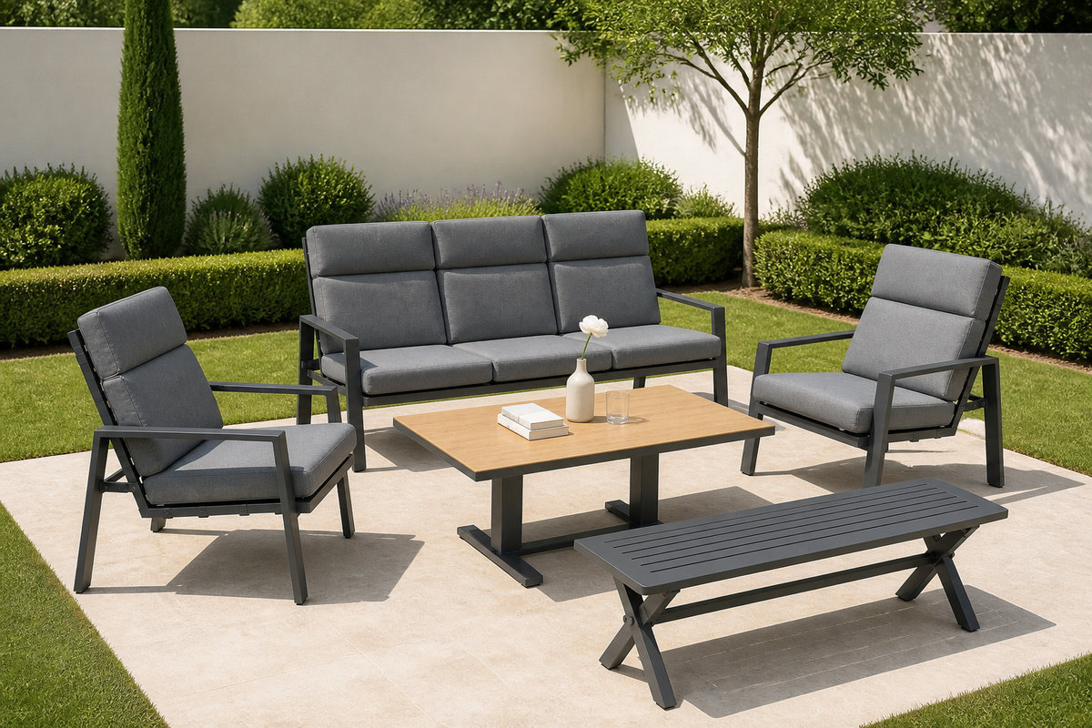 Outdoor sofa set with grey cushions and a pale-topped coffee table in a villa garden on a paved pad