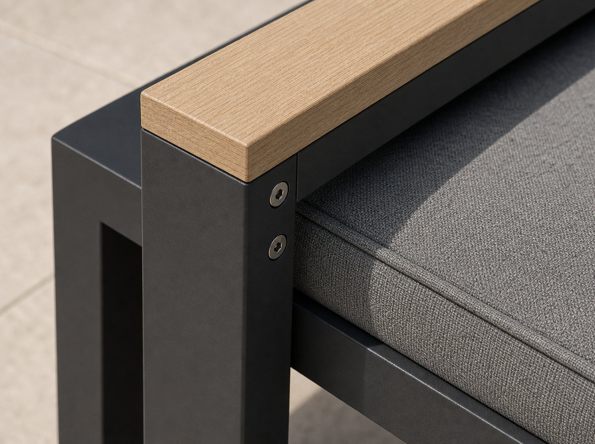 Close view of a charcoal square-section aluminium lounge armrest with a pale oak cap and a grey woven quick-dry cushion
