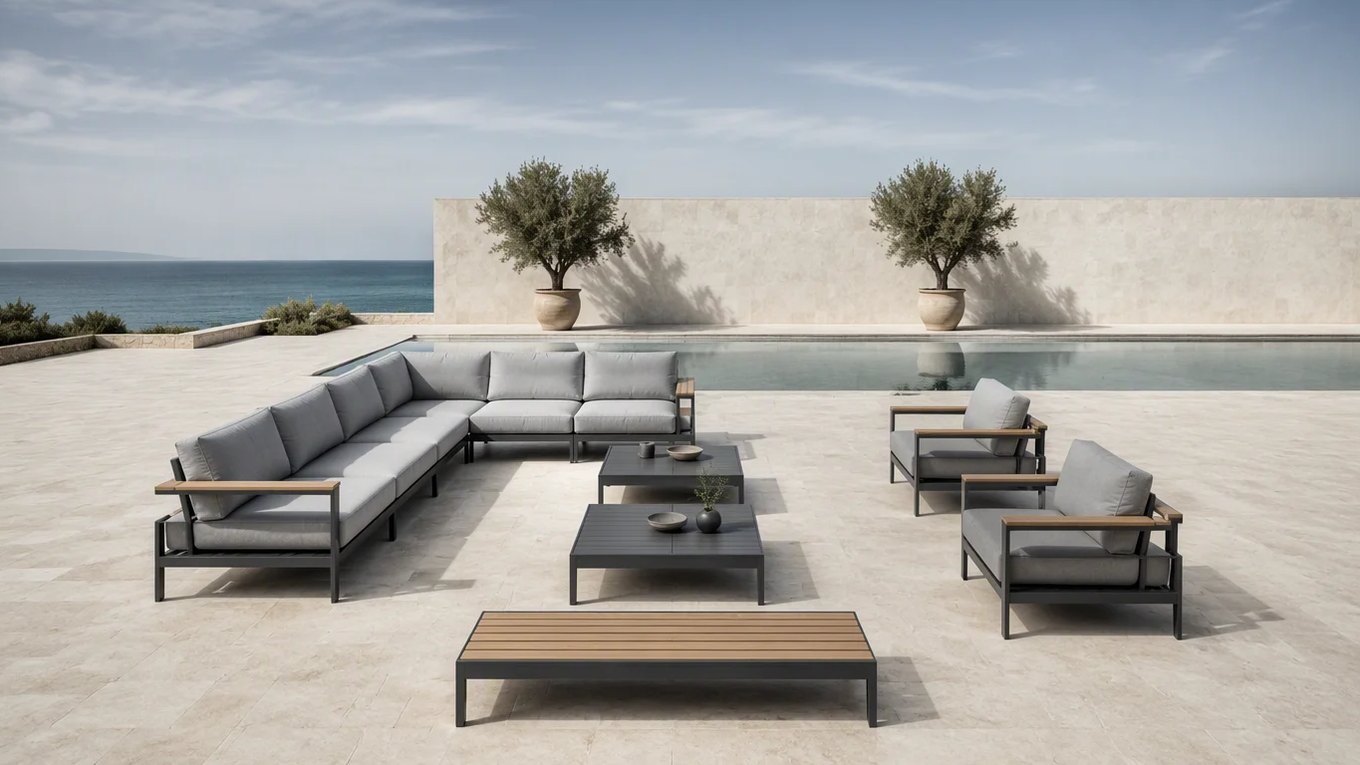 A slightly elevated view of a modular outdoor lounge layout on a hotel pool deck, showing the separate seat sections, armchairs, two coffee tables and a slatted bench set out with walkways between them