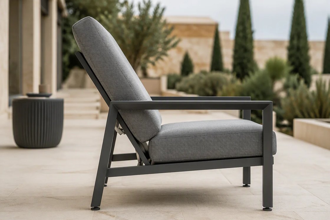 A high-back outdoor armchair with its back shown in the reclined position on a stone terrace