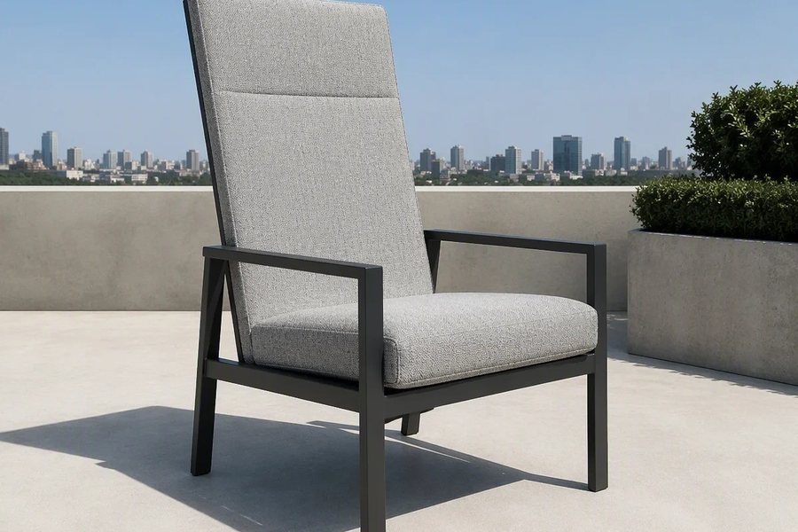 A light grey high-back outdoor armchair with a charcoal frame, on a city rooftop terrace