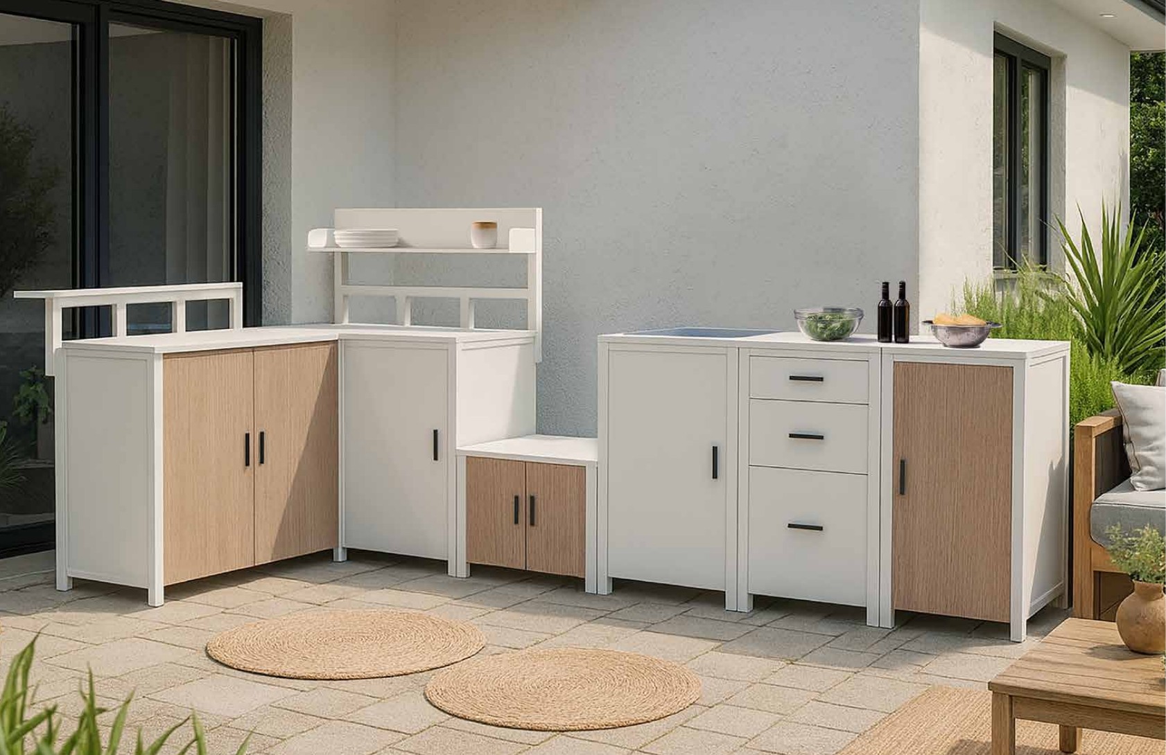 Modular outdoor kitchen units with aluminium carcasses, wood-effect doors and stone worktops arranged in an L-shape on a tiled terrace