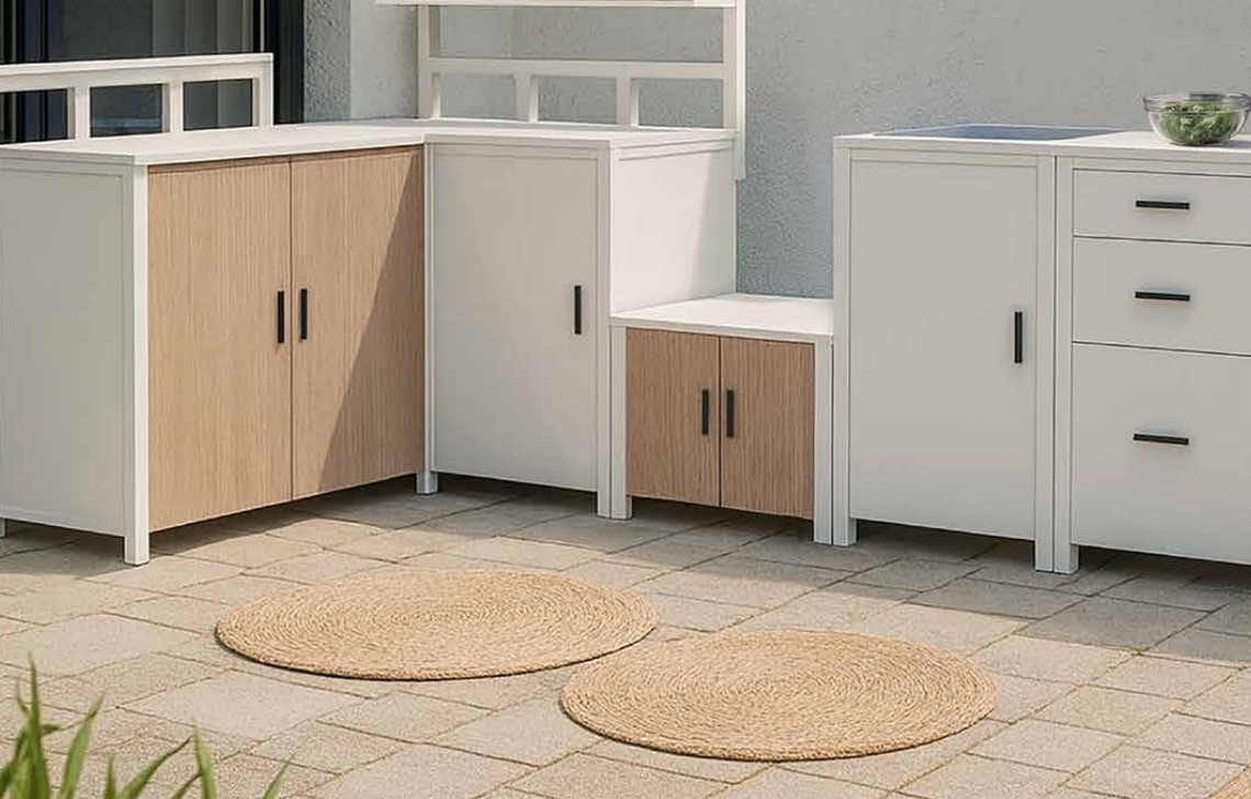The low table and the paving of a white outdoor kitchen run with jute rugs on the terrace