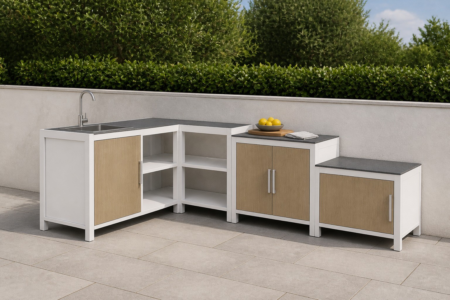 Outdoor kitchen units in white frames with wood grain door panels along a wall on a paved garden terrace