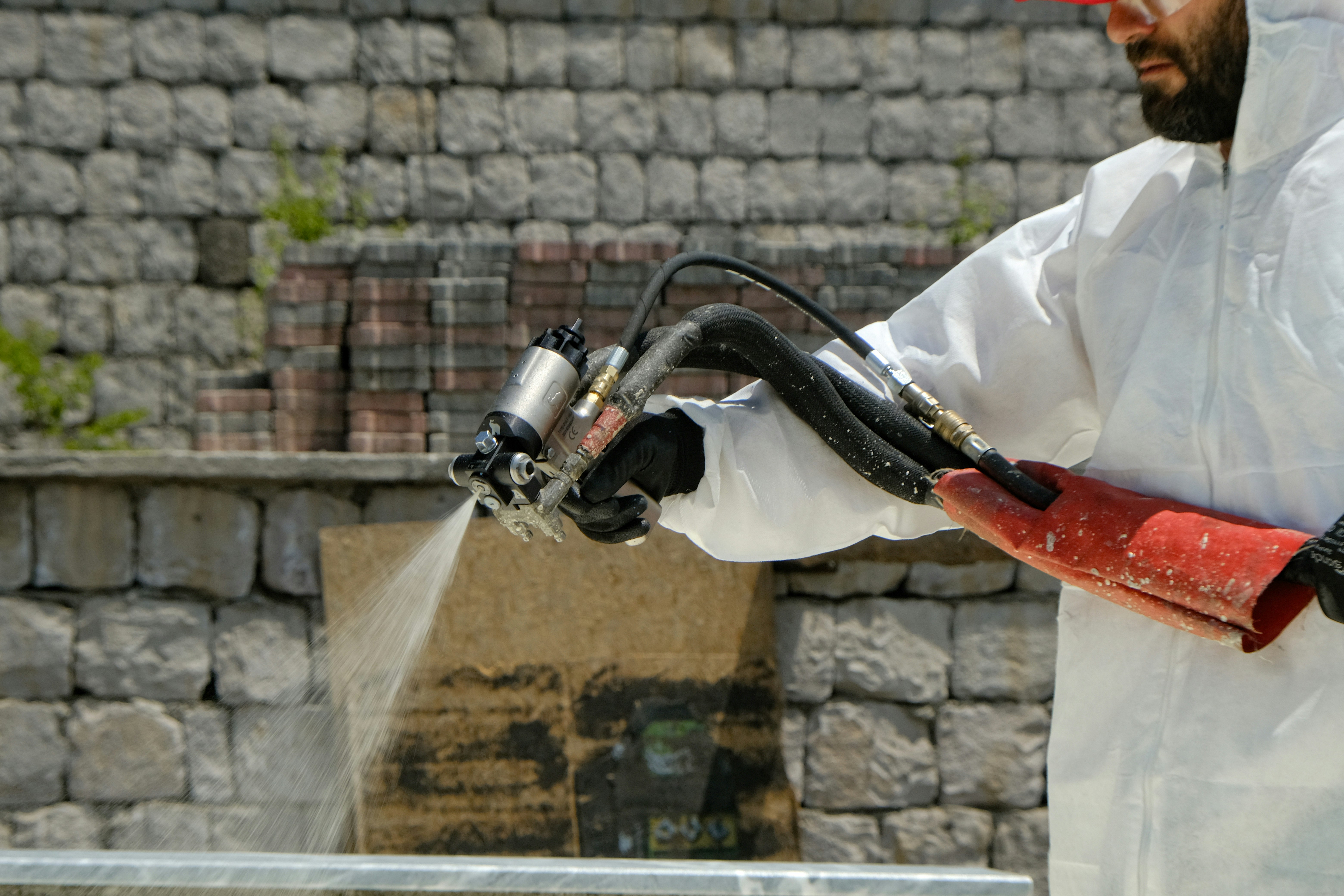 A technician wearing gloves carefully installs a hydraulic quick coupler onto a hose