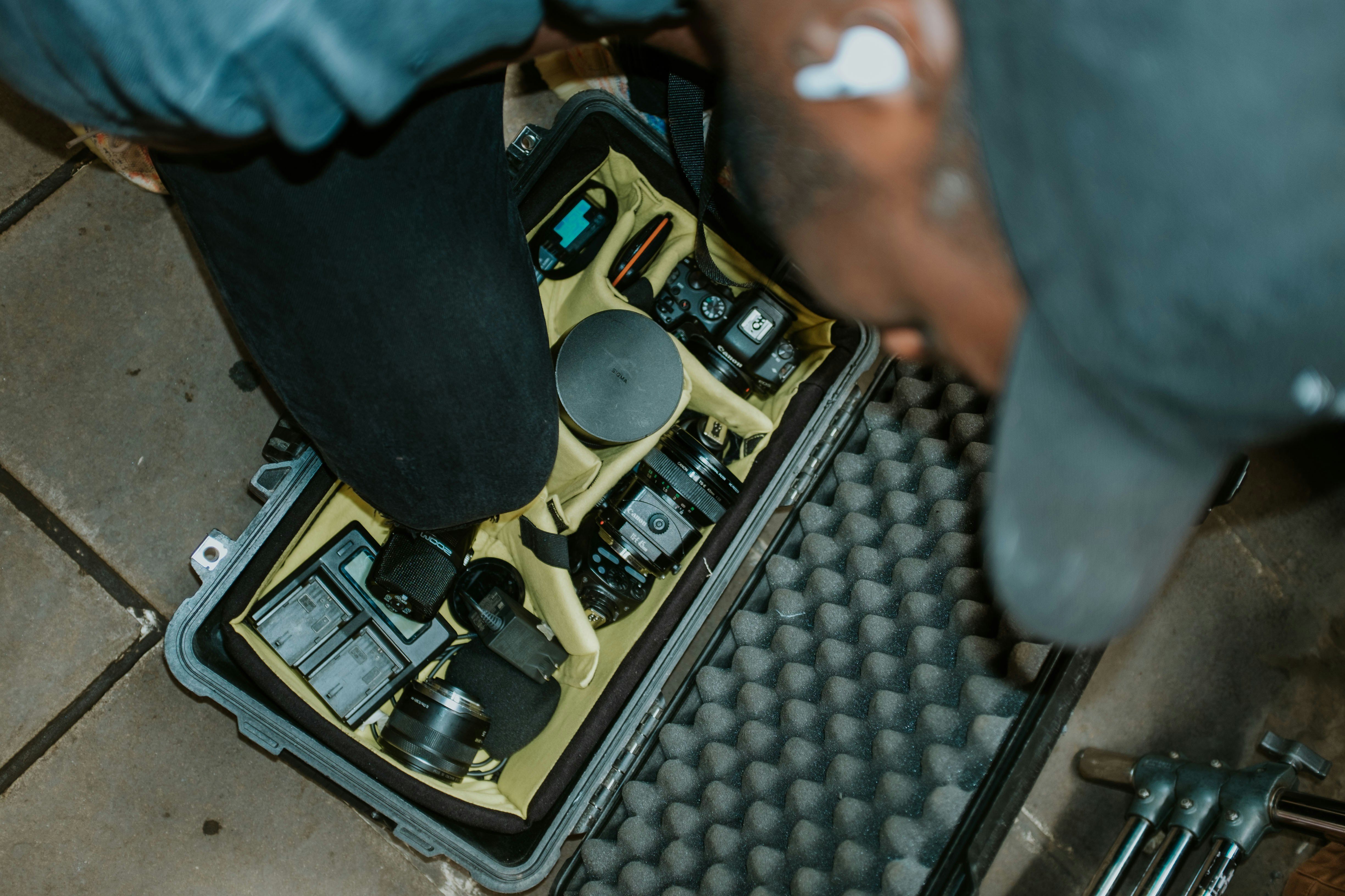 An operator wiping a flat-face hydraulic coupler clean before connecting it.