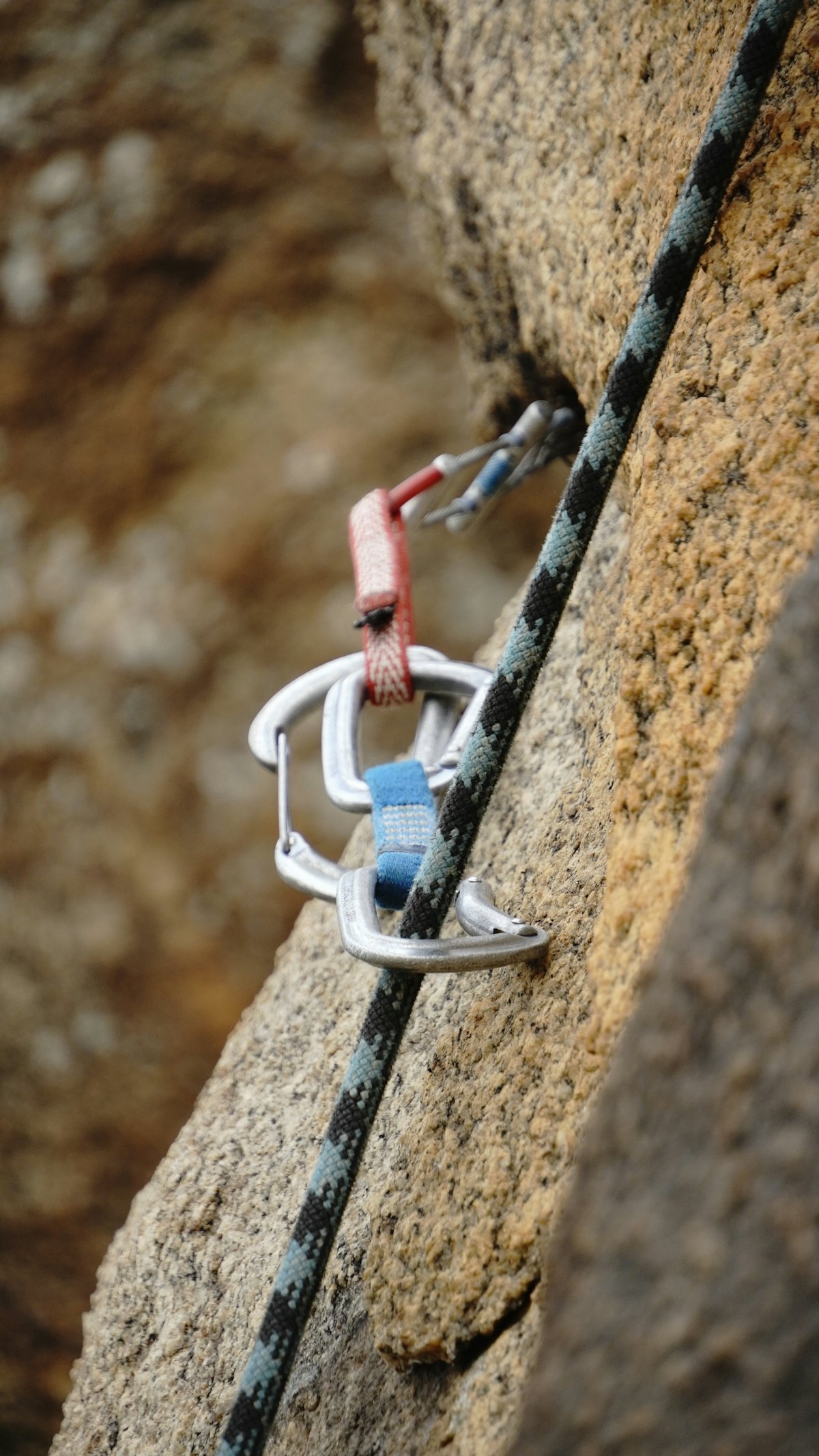 Carabiner and climbing rope secured on a rock face