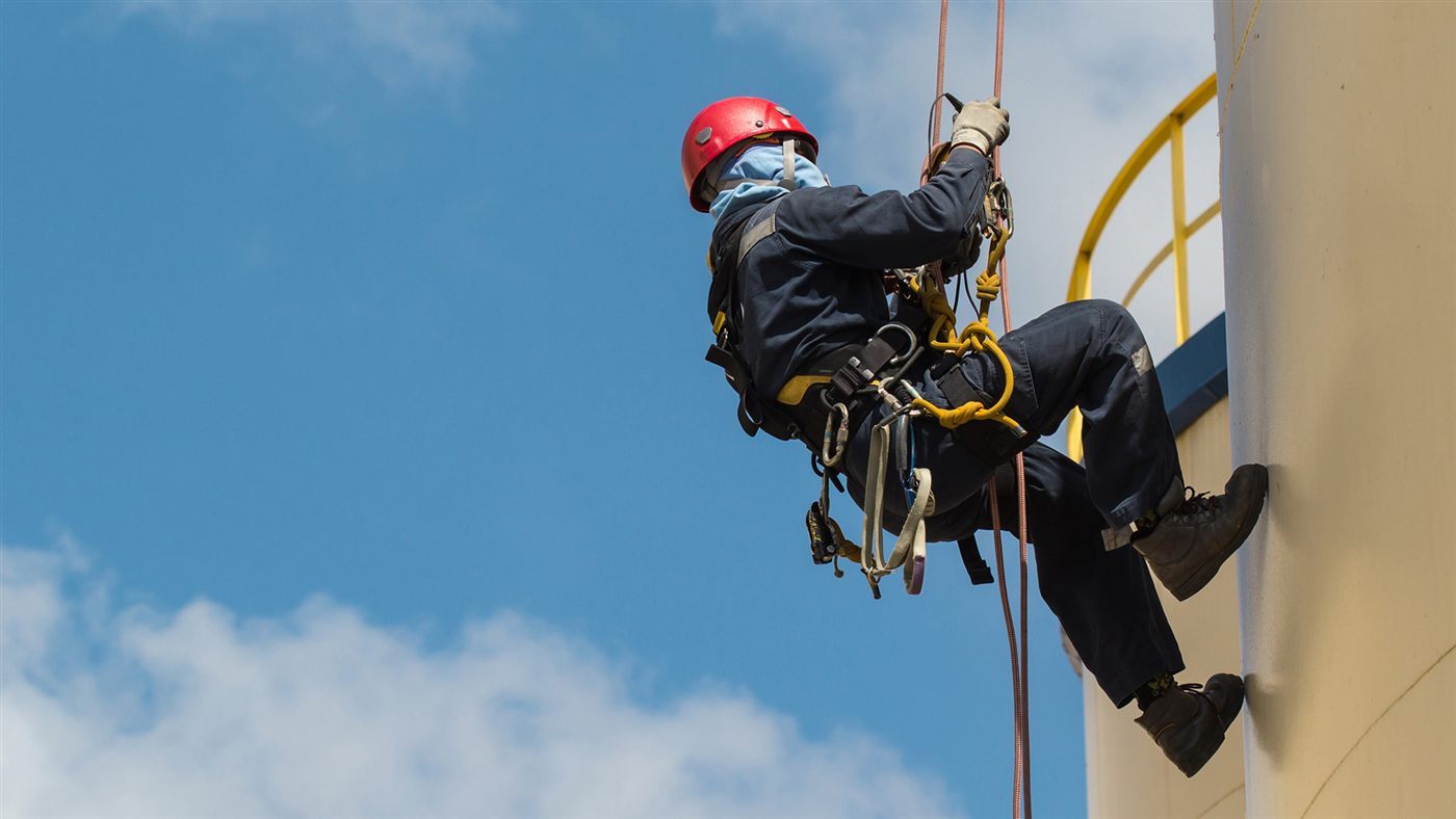 Industrial rope access worker using multiple aluminum locking carabiners