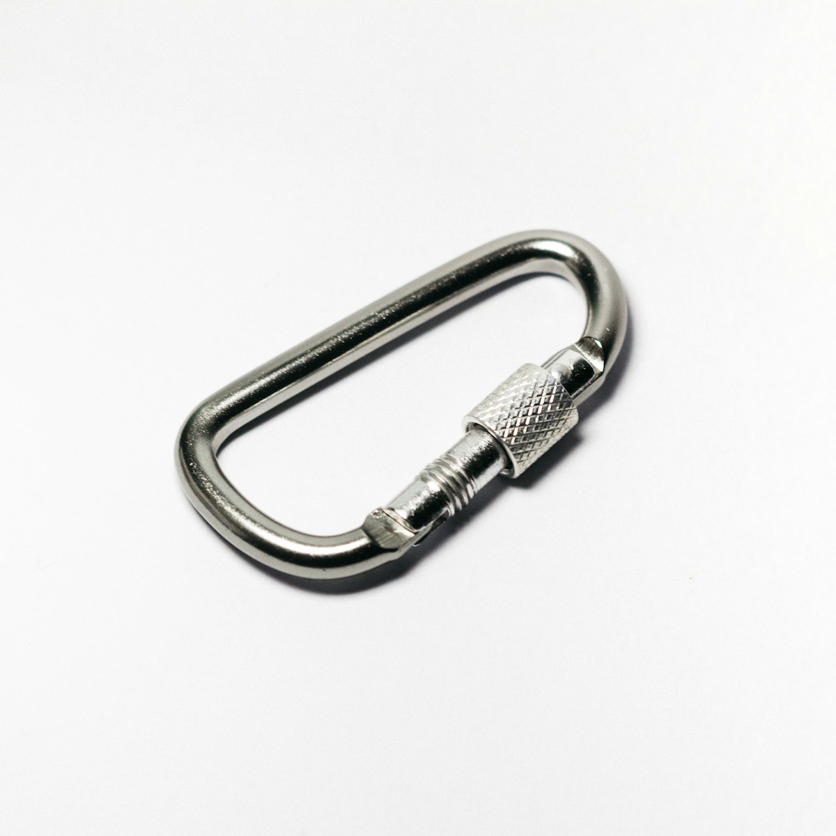 Close-up of a metal carabiner used to illustrate connector inspection points