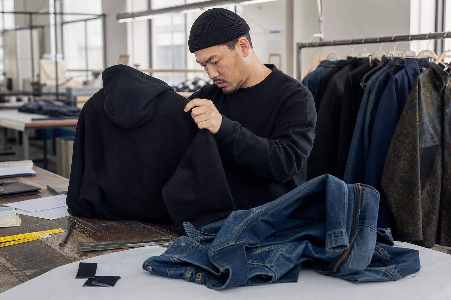Quality inspector checking a custom streetwear hoodie in an apparel workshop