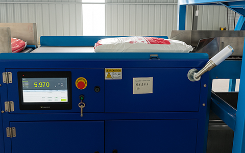 Dynamic checkweigher inspecting fertilizer bags on production line