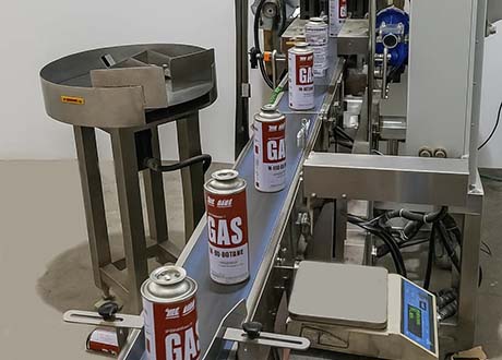 Explosion-proof checkweigher inspecting aerosol cans in chemical packaging line.