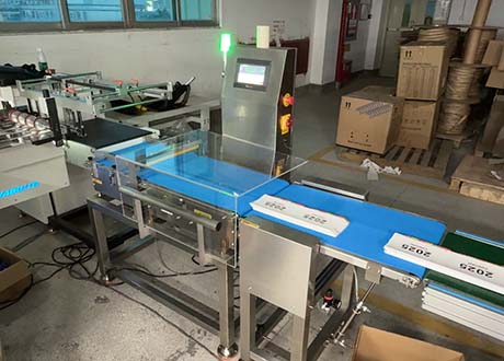 Dynamic checkweigher inspecting printed cards on a high-speed checkweighing system for packaging quality control and compliance