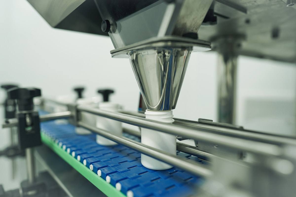 Automated filling line dispensing product into white bottles