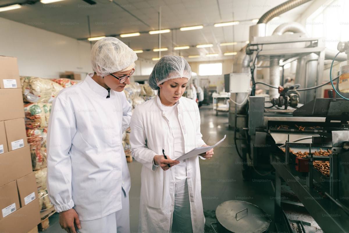 Two quality inspectors reviewing records in a food plant