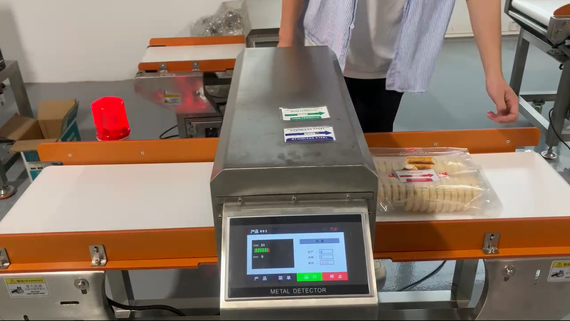 Metal detector on conveyor belt at the end of production line inspects yam cakes