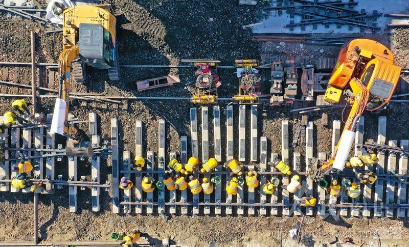 track crew and measuring tools working on a railway section