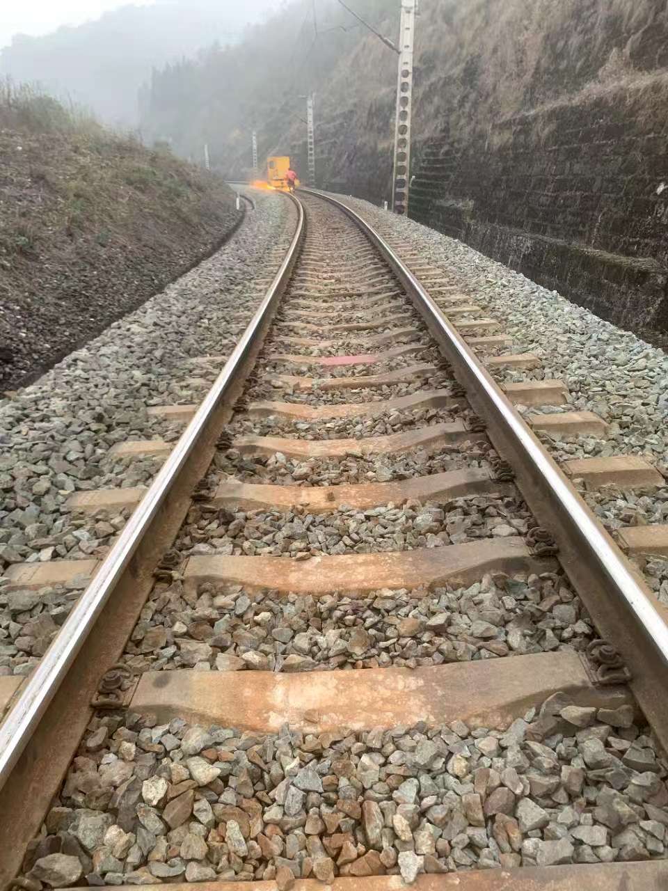 rail grinding operations on a station section with track staff and machine support equipment present
