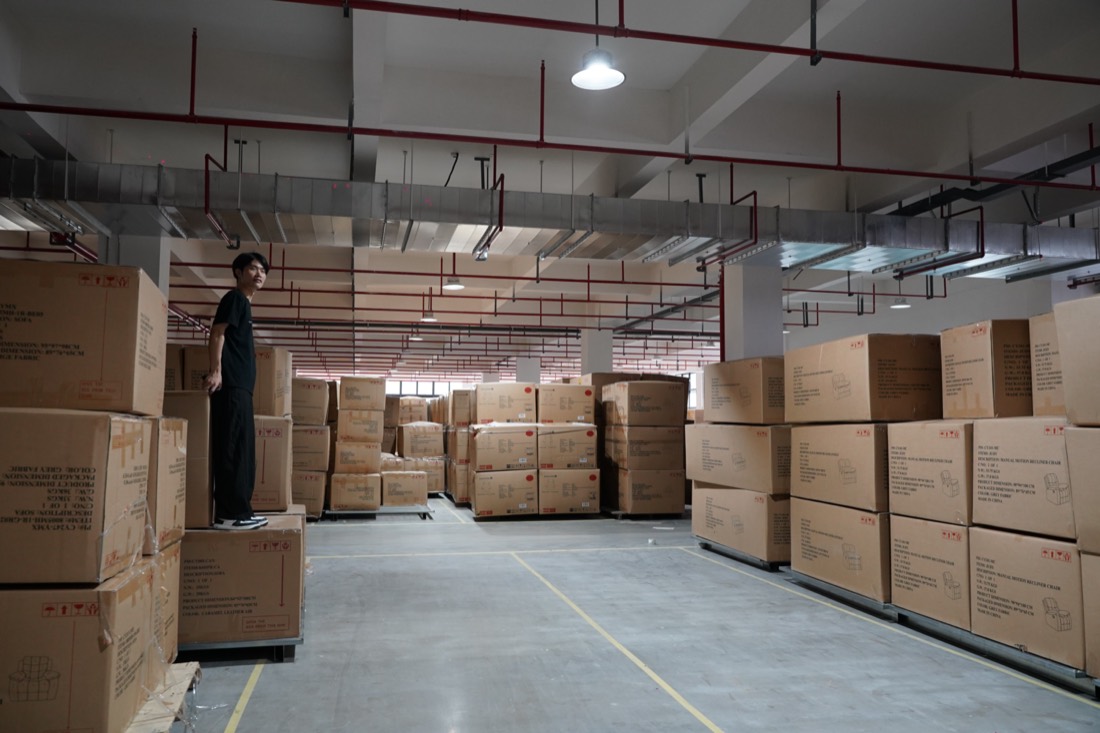 Packed recliner sofa cartons stacked in a warehouse awaiting container loading