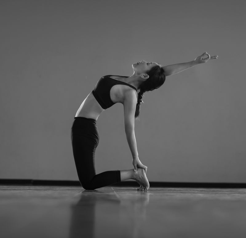 Athlete in black activewear demonstrating a signature yoga pose