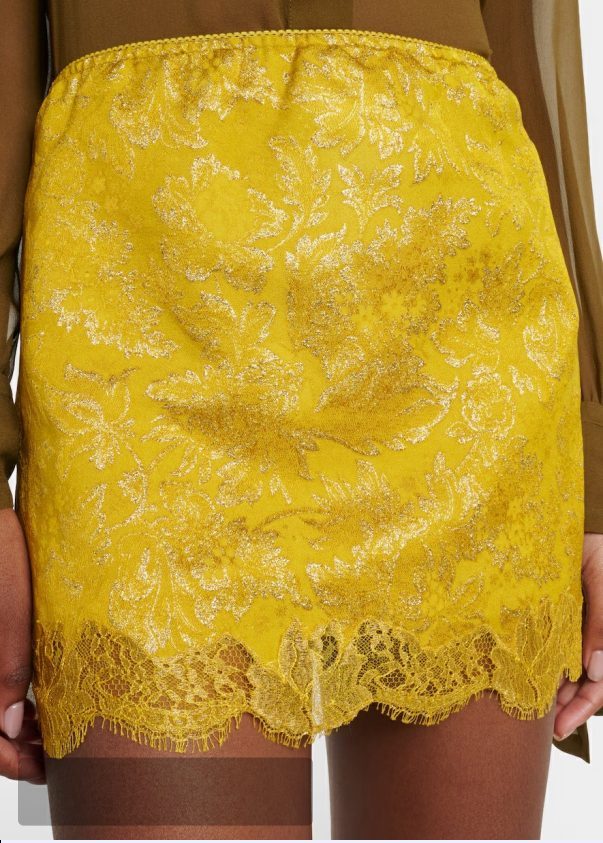 A yellow lace mini skirt styled as the deck’s signature focal-point layer — a key FW26 piece