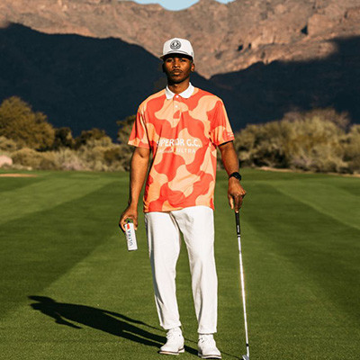 Professional golfer demonstrating performance trousers fit and drape on pristine course