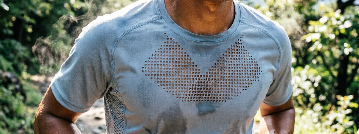 Close-up of a male runner in a laser-cut mesh running t-shirt on an outdoor trail