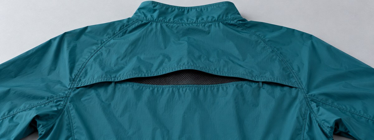Teal running jacket upper-back overlapping vent with mesh beneath
