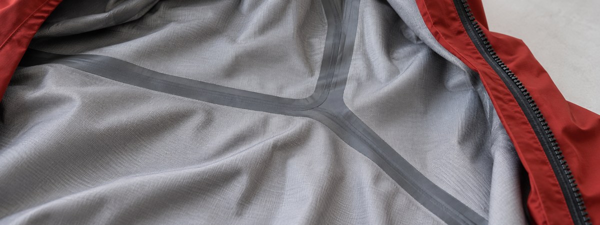 Inner hardshell backer with seam sealing tape over a seam junction