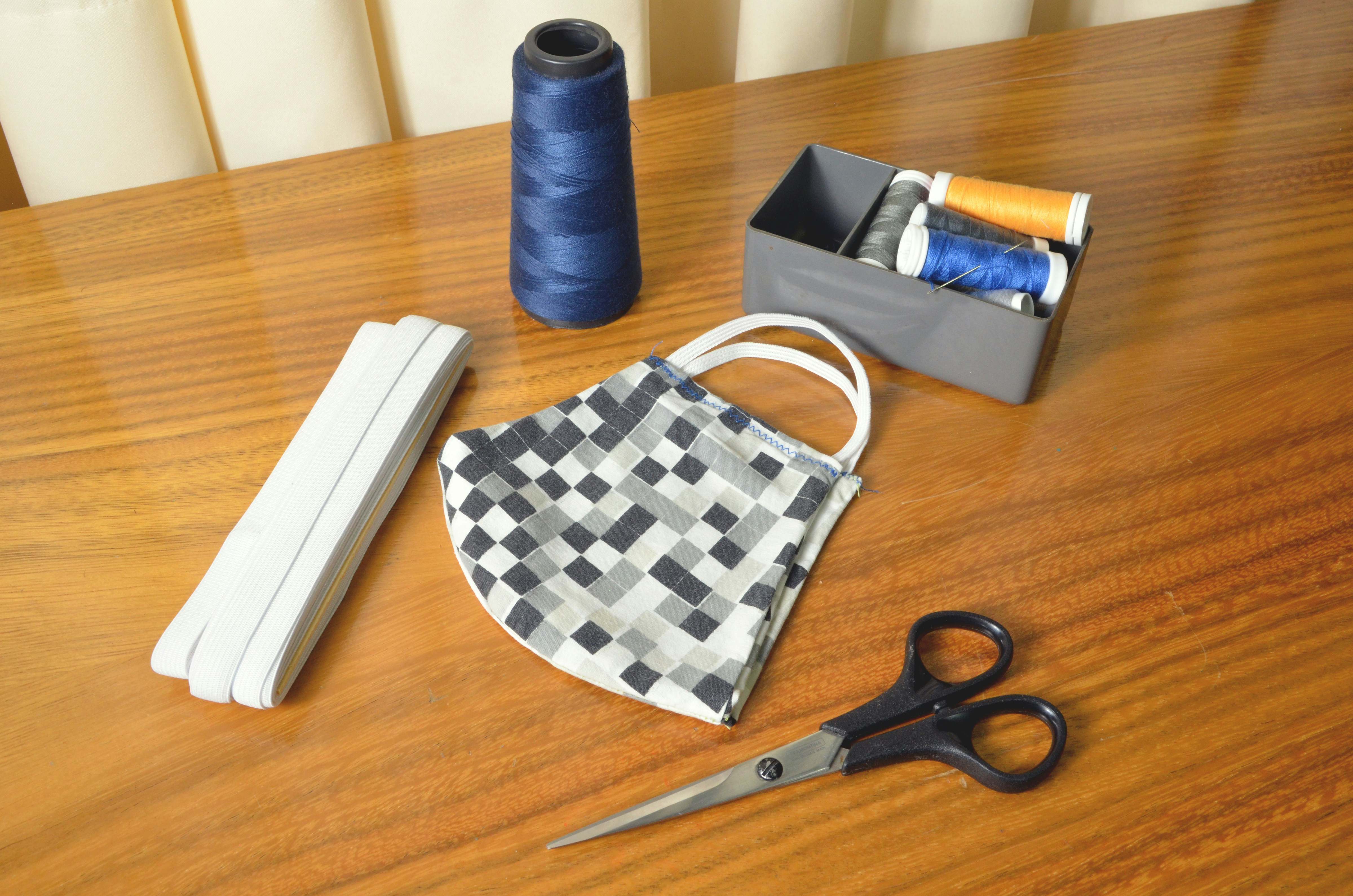 A self-healing cutting mat with patterned legging fabric, a rotary cutter, and pattern weights on top.