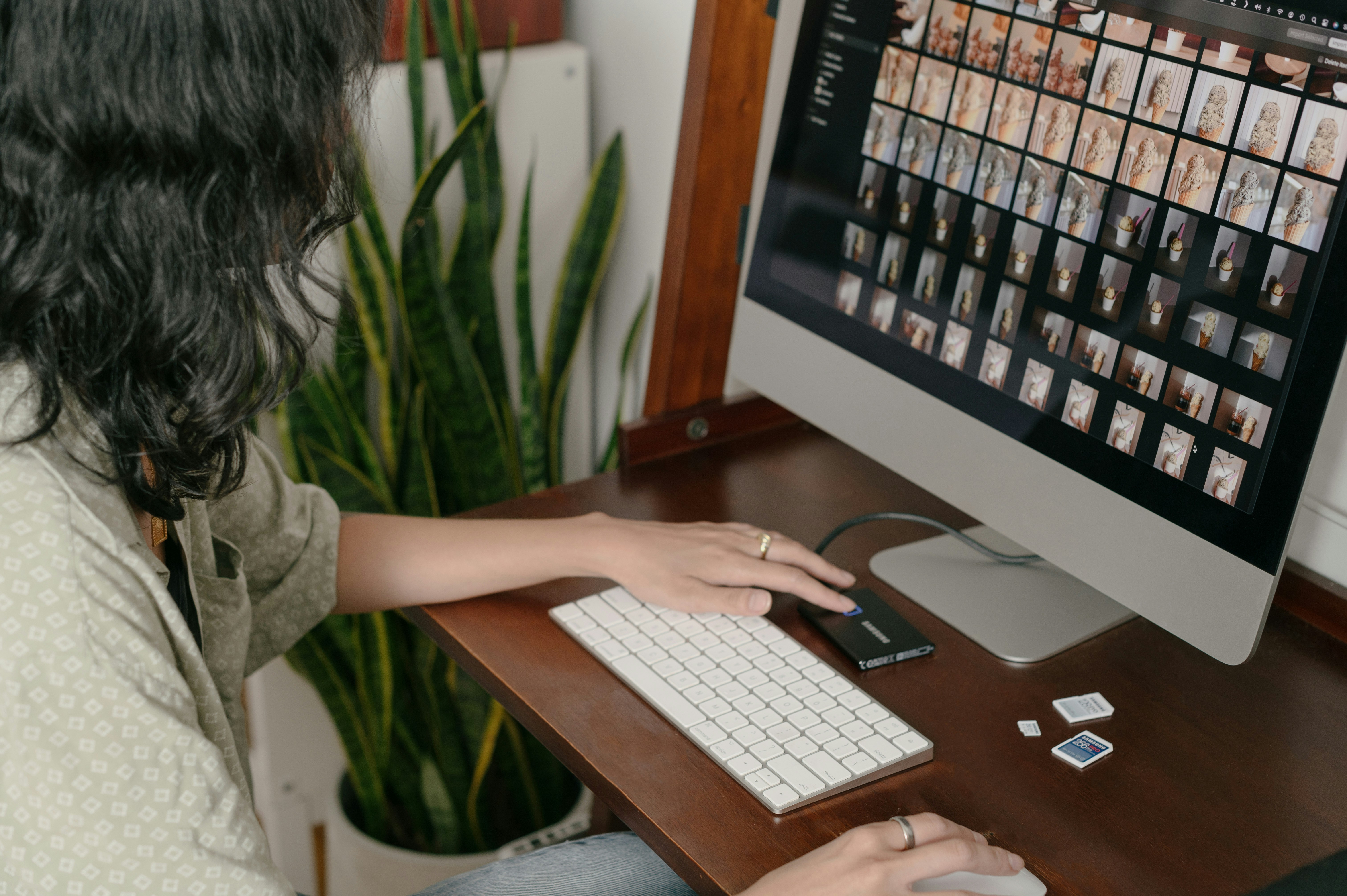 A person using a computer to design a colorful pattern for leggings on a print-on-demand website interface.