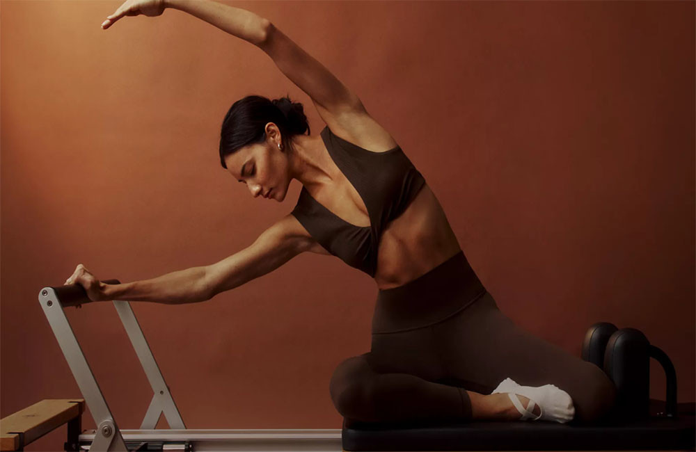 A woman in a downward-facing dog pose, wearing a comfortable and supportive yoga bra.