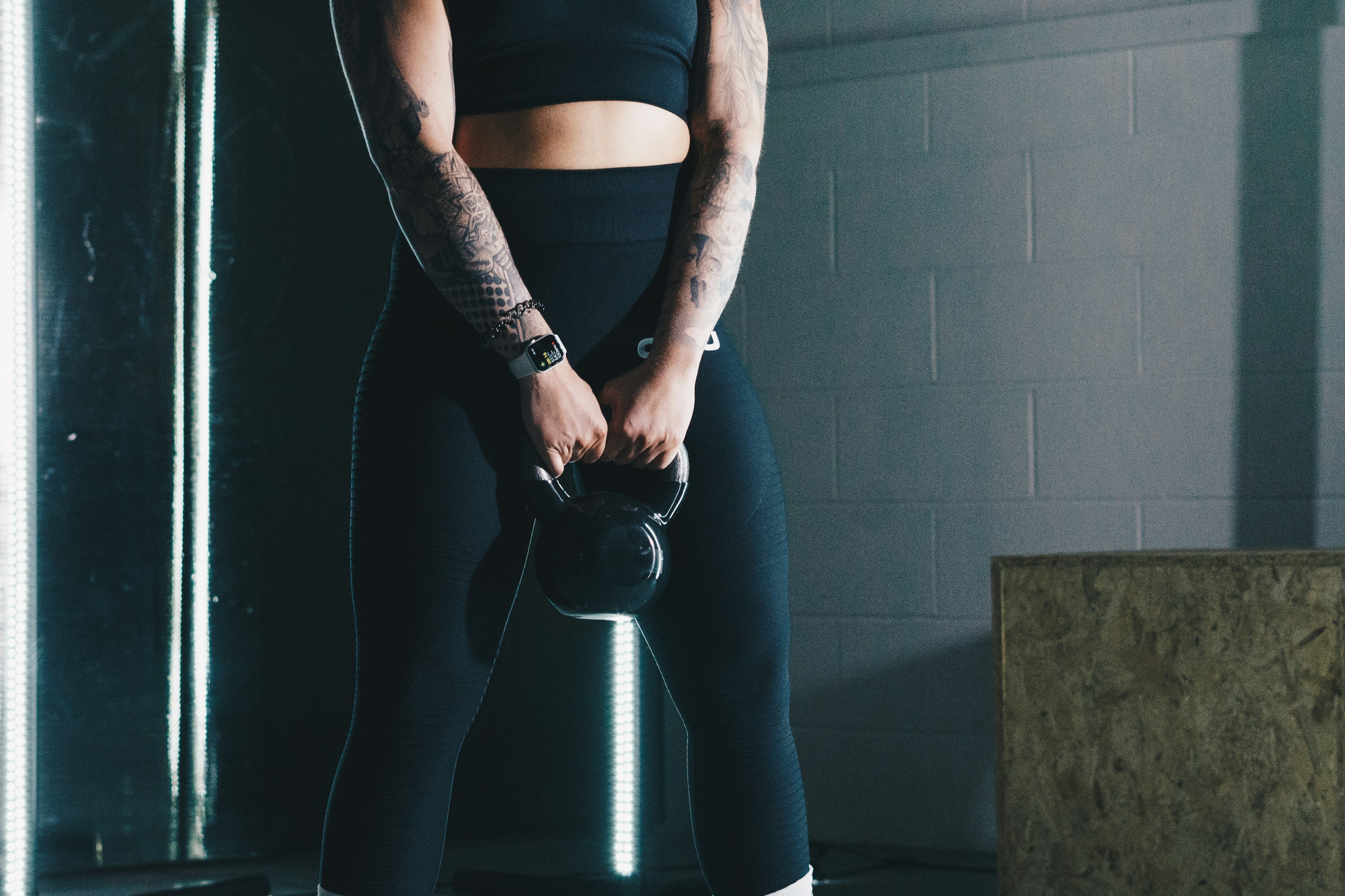 Woman in a gym wearing leggings and a sports bra, ready to work out