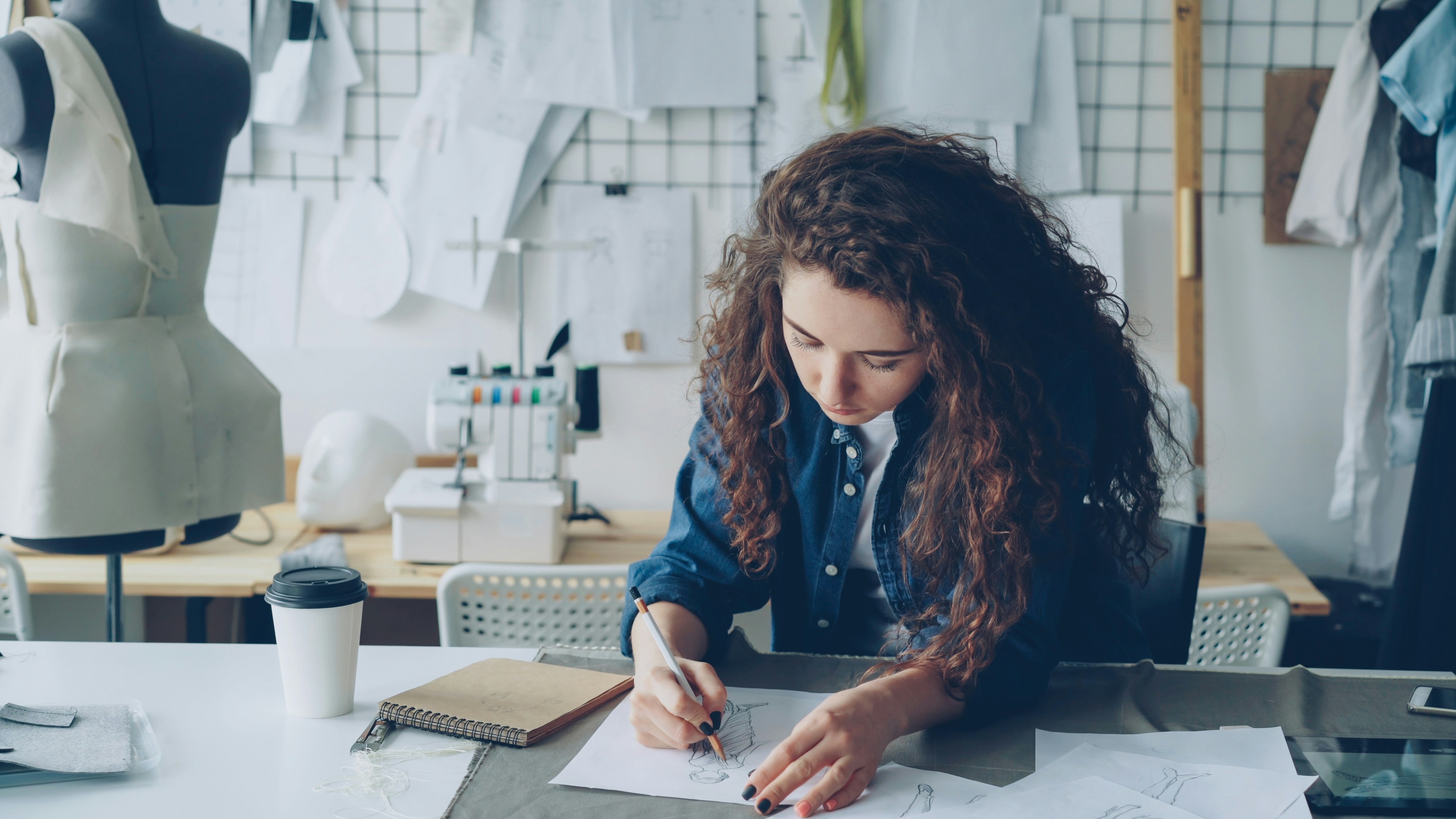 A designer reviewing technical drawings and fabric swatches for yoga wear production.