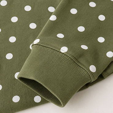Detalle del puño de manga de una sudadera de polka personalizada en verde oliva