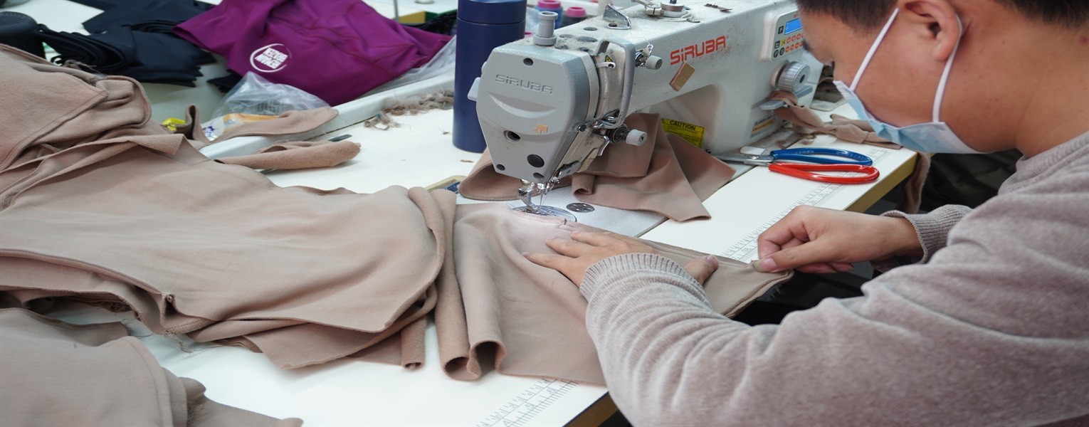 Bloomto workshop operator sewing stretch fabric for custom activewear production