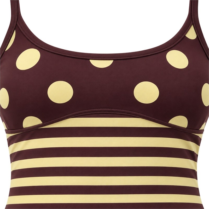 Curved seam joining polka dots and horizontal stripes on the yoga set top