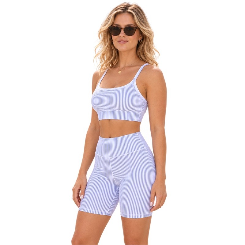 Three-quarter view of a woman wearing a light lavender and white striped cami and high-waist shorts set