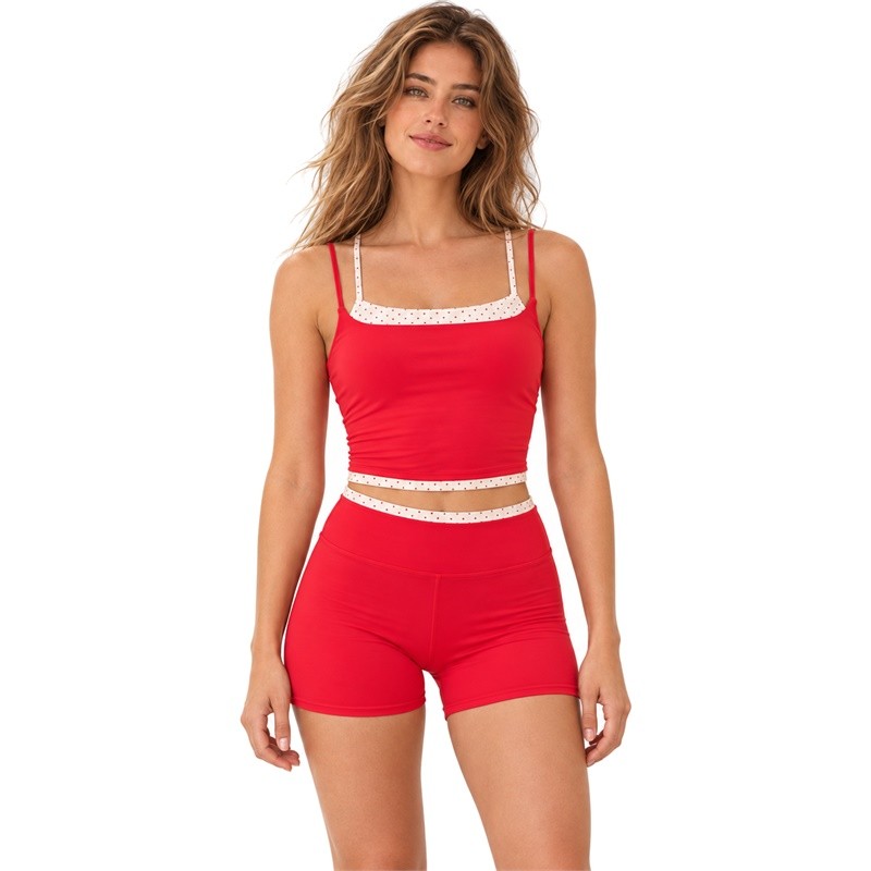 Front view of a red double-strap crop top and high-waist shorts with cream polka dot trim
