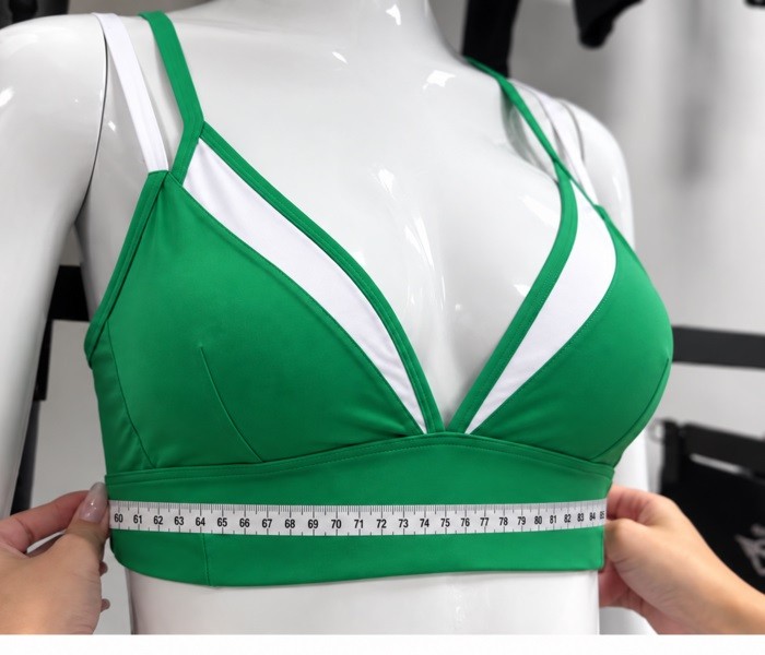 Measuring the underband of a green and white custom yoga bra on a mannequin